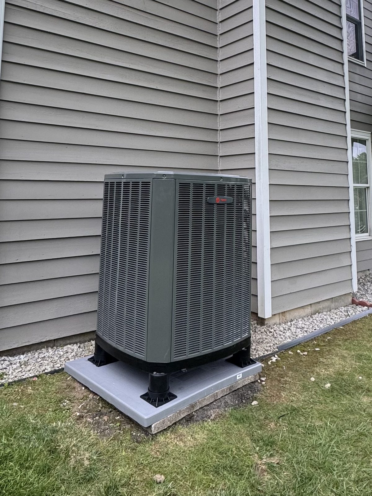 Trane heat pump outdoor unit installed on a composite pad by Lumen Heating and Cooling